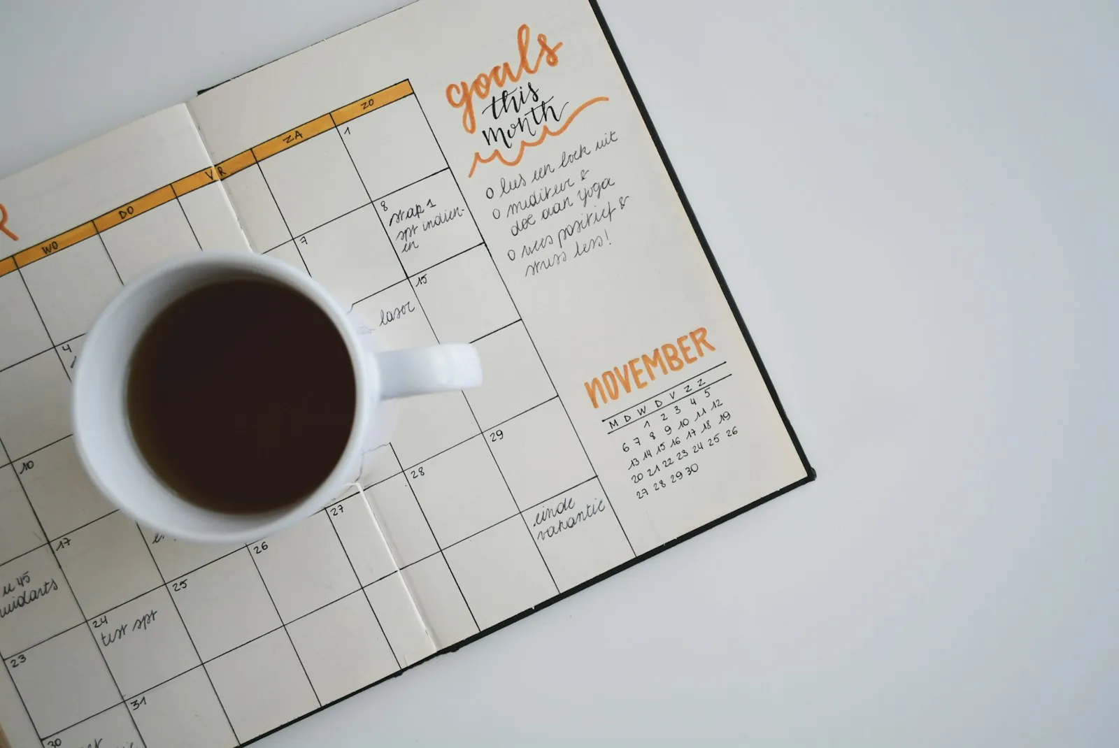 Coffee mug resting on an open planner
