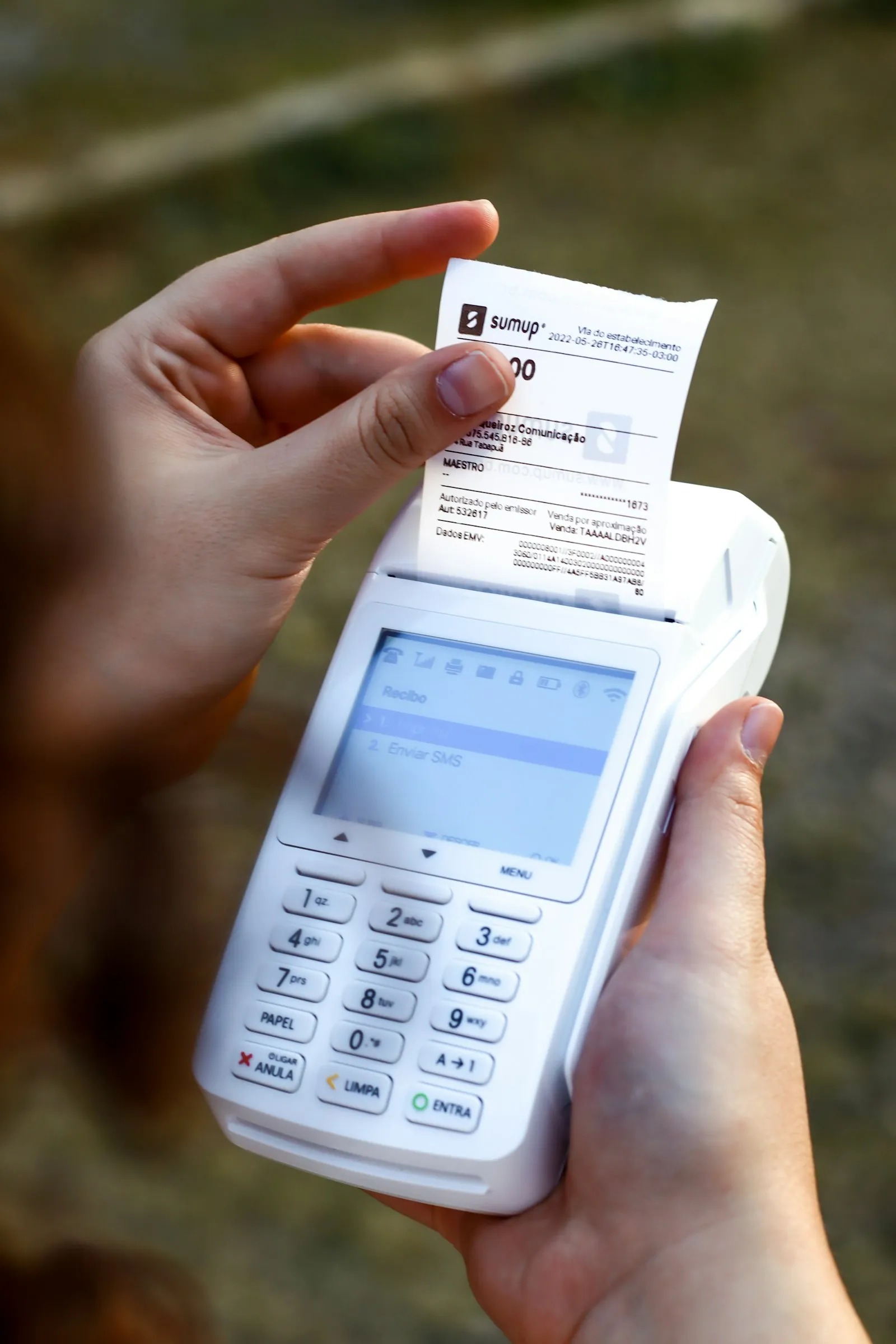 Person holding a phone and a receipt while checking costs