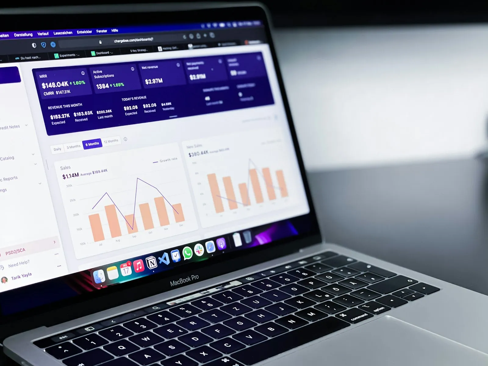A laptop on a desk showing a dashboard of sales charts