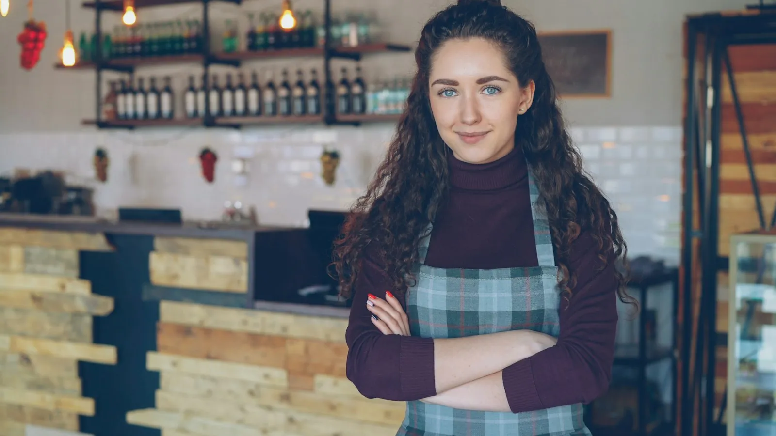 A smiling owner standing in her coffee shop