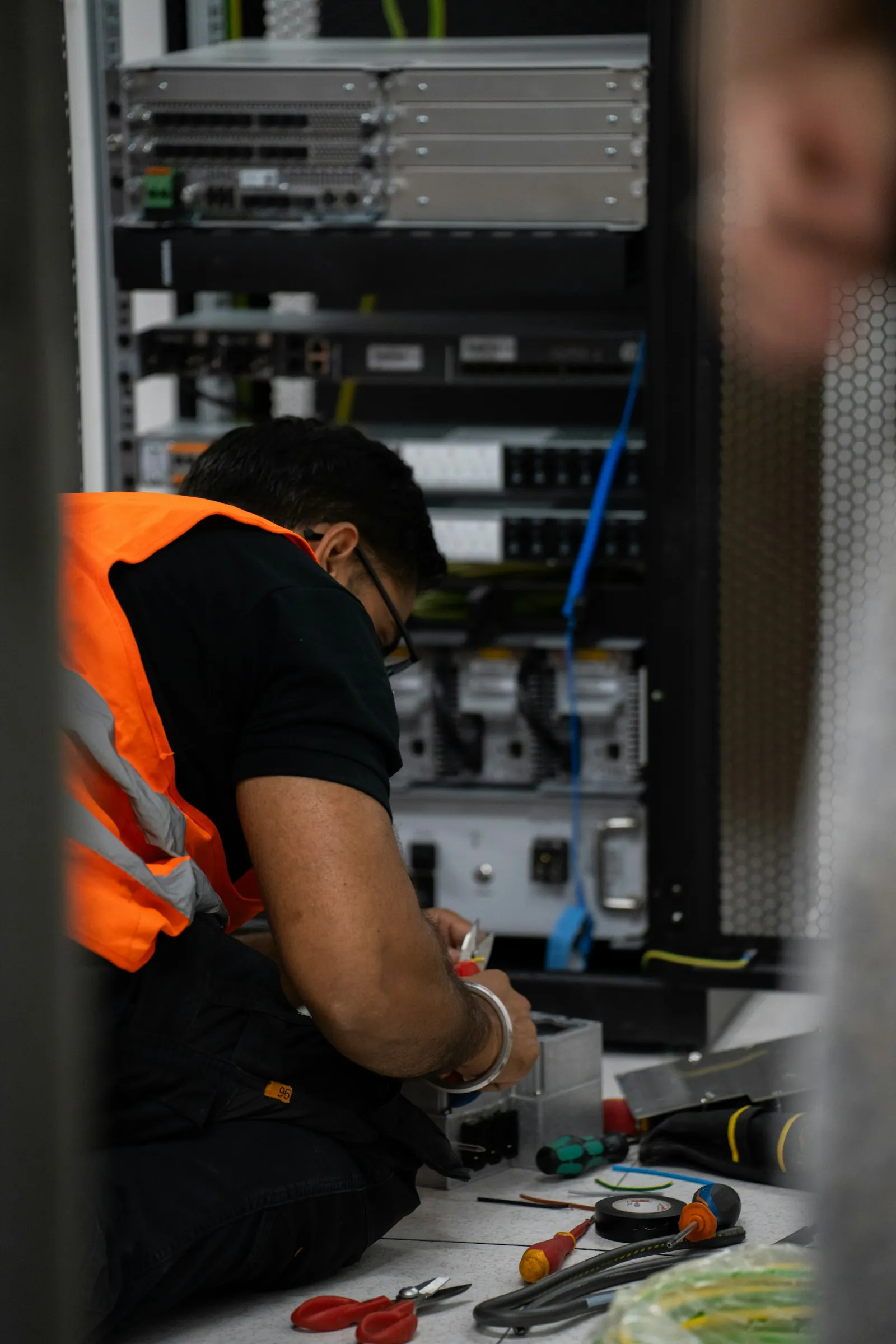 A technician working on server equipment with tools