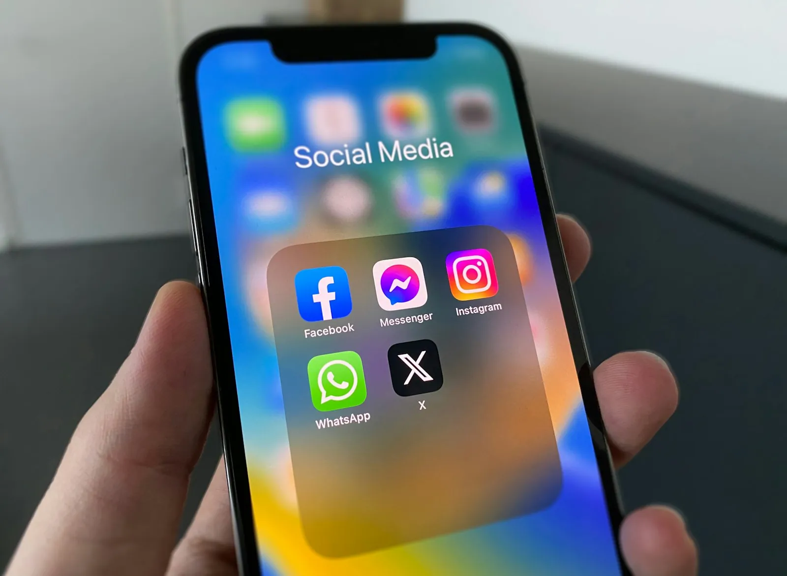 A person holding a phone with a social media feed on screen