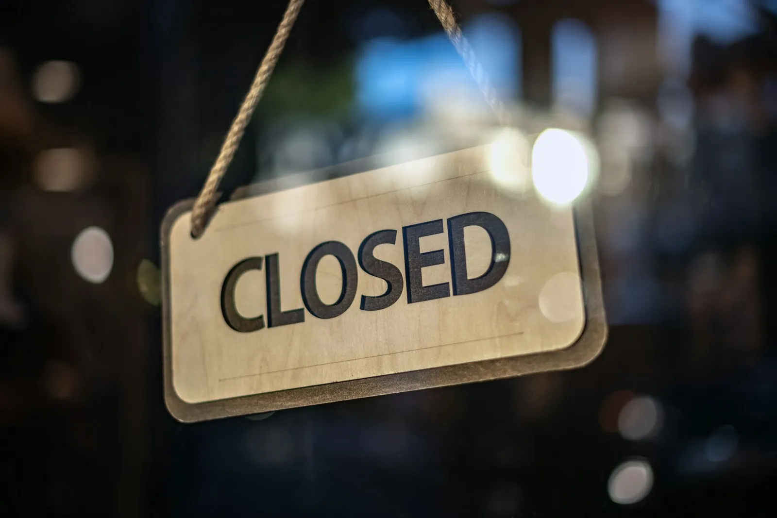 A closed sign hanging on a shop's glass door